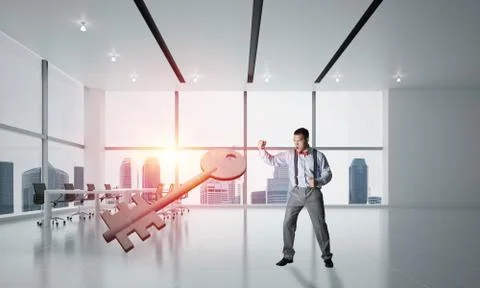 Breaking through access concept with furious man crashing concrete key 스톡 사진