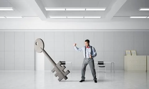 Breaking through access concept with furious man crashing concrete key Stock Photos