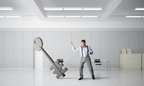 Breaking through access concept with furious man crashing concrete key 스톡 사진
