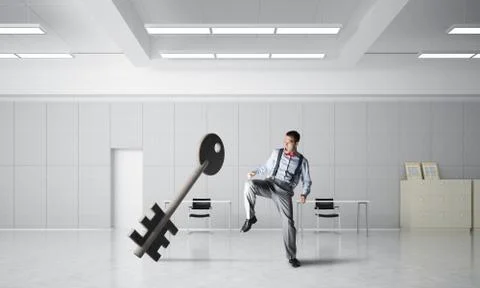 Breaking through access concept with furious man crashing concrete key Stock Photos