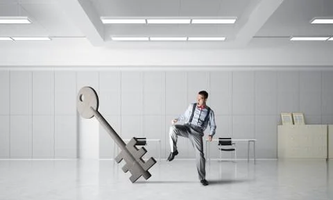 Breaking through access concept with furious man crashing concrete key 스톡 사진