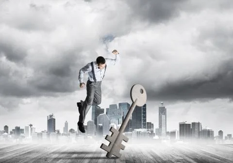 Breaking through access concept with furious man crashing concrete key 스톡 사진