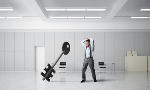 Breaking through access concept with furious man crashing concrete key Stock Photos