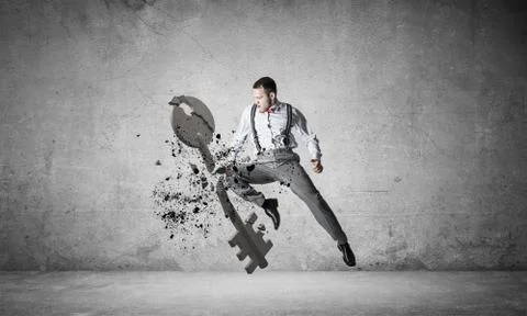 Breaking through access concept with furious man in room crashing concrete key Stock Photos