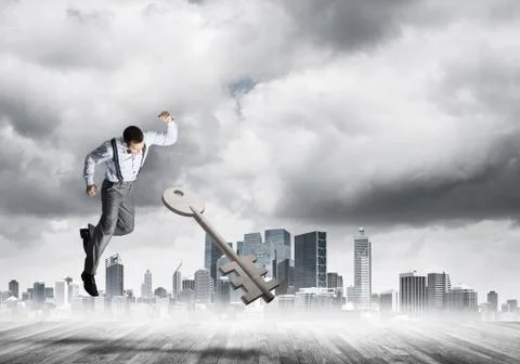 Breaking through access concept with furious man crashing concrete key 스톡 사진