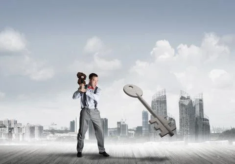 Breaking through access concept with furious man crashing concrete key Stock Photos