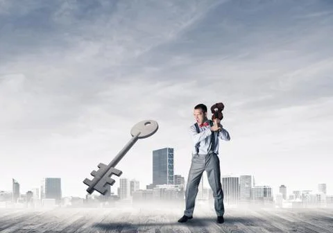 Breaking through access concept with furious man crashing concrete key 스톡 사진