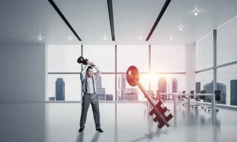Breaking through access concept with furious man crashing concrete key 스톡 사진