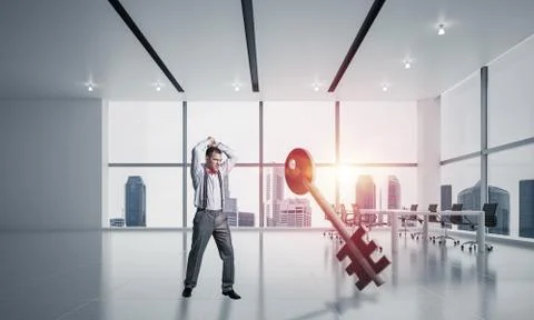 Breaking through access concept with furious man crashing concrete key 스톡 사진