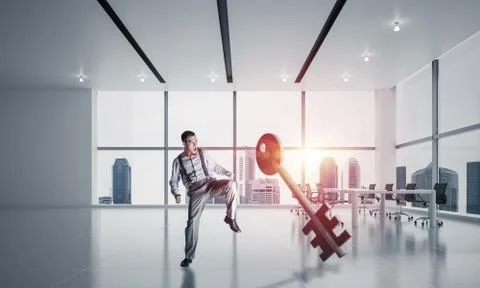 Breaking through access concept with furious man crashing concrete key 스톡 사진