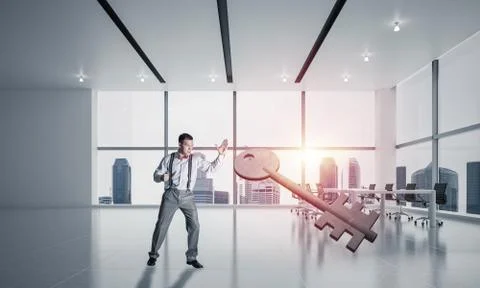 Breaking through access concept with furious man crashing concrete key 스톡 사진