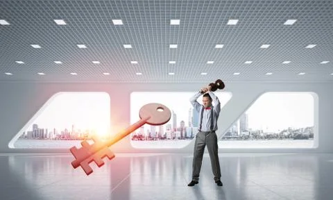 Breaking through access concept with furious man crashing concrete key 스톡 사진