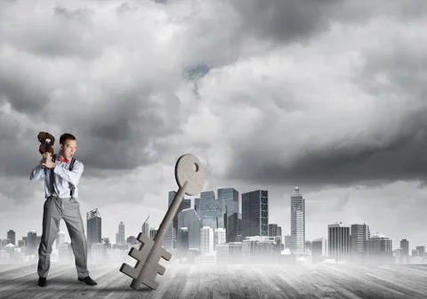 Breaking through access concept with furious man crashing concrete key Stock Photos