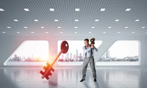 Breaking through access concept with furious man crashing concrete key Stock Photos