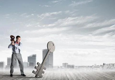 Breaking through access concept with furious man crashing concrete key Stock Photos