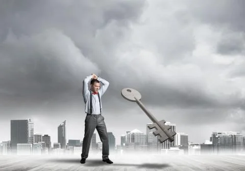 Breaking through access concept with furious man crashing concrete key Stock Photos