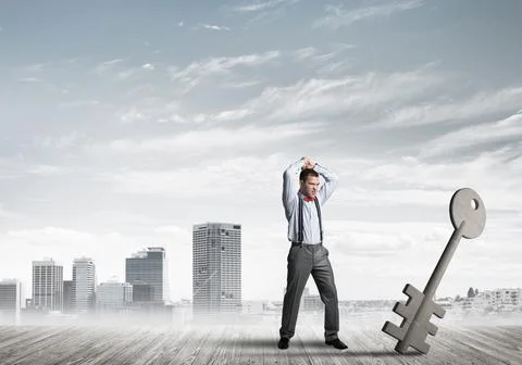 Breaking through access concept with furious man crashing concrete key 스톡 사진