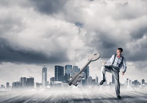 Breaking through access concept with furious man crashing concrete key 스톡 사진