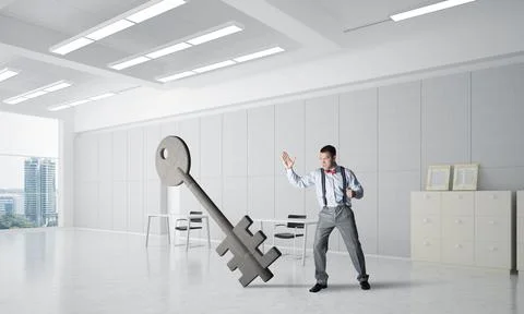 Breaking through access concept with furious man crashing concrete key Stock Photos
