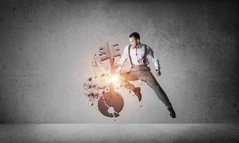Breaking through access concept with furious man in room crashing concrete key 스톡 사진