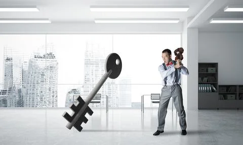 Breaking through access concept with furious man crashing concrete key 스톡 사진