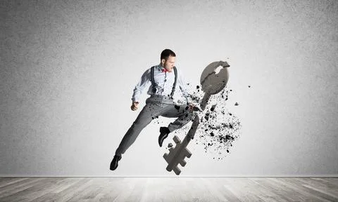 Breaking through access concept with furious man in room crashing concrete key Stock Photos