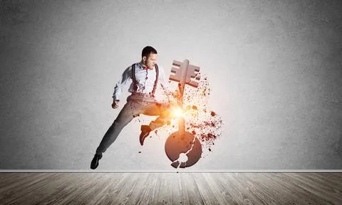 Breaking through access concept with furious man in room crashing concrete key Stock Photos