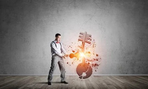 Breaking through access concept with man in room crashing concrete key 스톡 사진