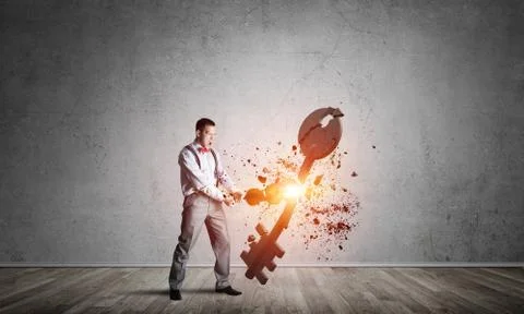 Breaking through access concept with man in room crashing concrete key Stock Photos
