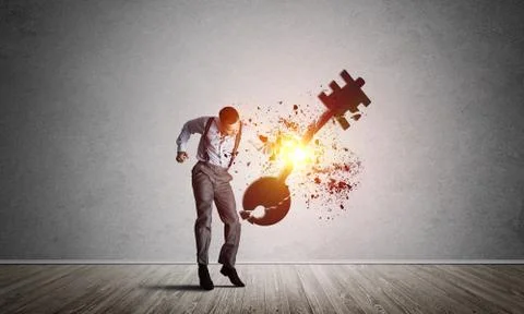 Breaking through access concept with man in room crashing concrete key 스톡 사진