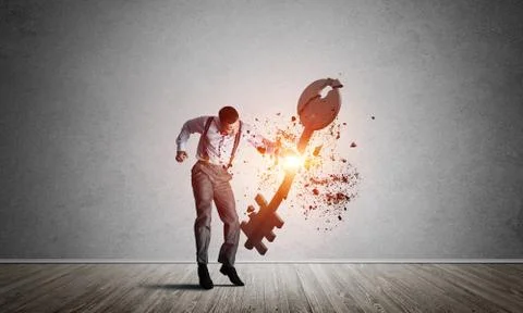 Breaking through access concept with man in room crashing concrete key Stock Photos