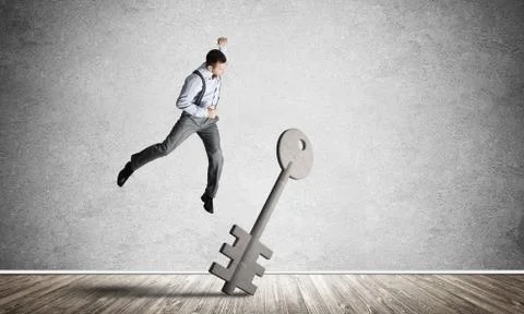 Breaking through access concept with man in room crashing concrete key Stock Photos