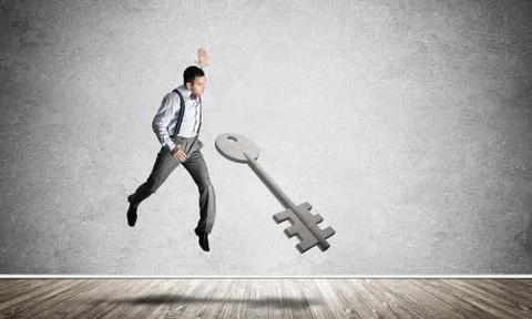 Breaking through access concept with man in room crashing concrete key Stock Photos