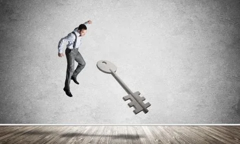 Breaking through access concept with man in room crashing concrete key Stock Photos