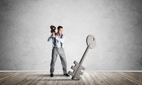 Breaking through access concept with man in room crashing concrete key Stock Photos
