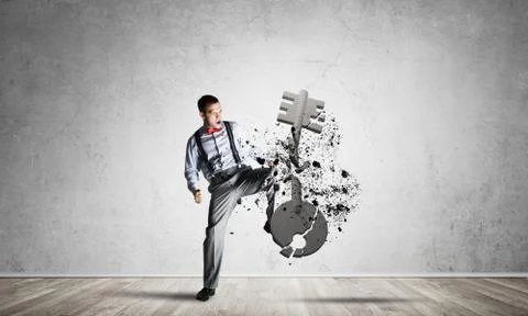 Breaking through access concept with man in room crashing concrete key 스톡 사진