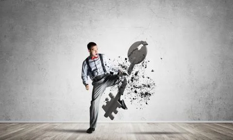 Breaking through access concept with man in room crashing concrete key Stock Photos