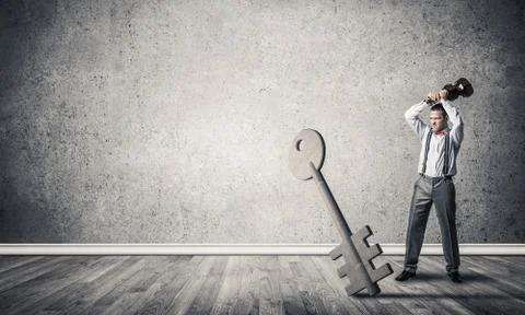 Breaking through access concept with man in room crashing concrete key Stock Photos