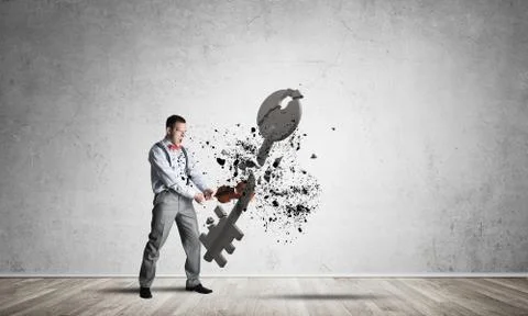 Breaking through access concept with man in room crashing concrete key Stock Photos