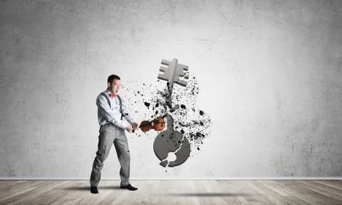 Breaking through access concept with man in room crashing concrete key Stock Photos