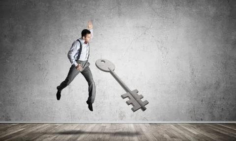 Breaking through access concept with man in room crashing concrete key Stock Photos