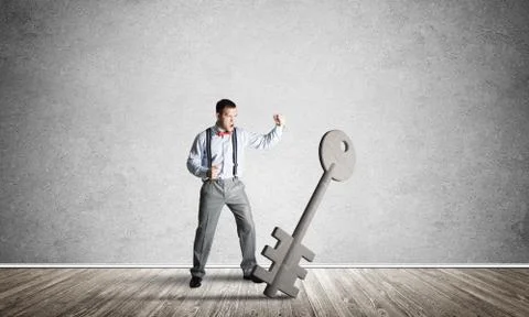 Breaking through access concept with man in room crashing concrete key Stock Photos