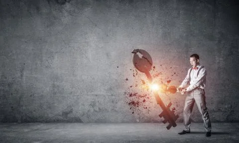 Breaking through access concept with man in room crashing concrete key 스톡 사진