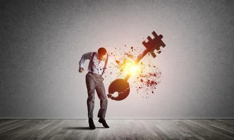 Breaking through access concept with man in room crashing concrete key 스톡 사진
