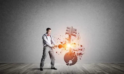 Breaking through access concept with man in room crashing concrete key 스톡 사진