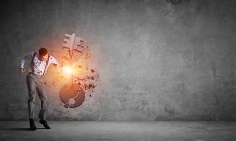 Breaking through access concept with man in room crashing concrete key Stock Photos