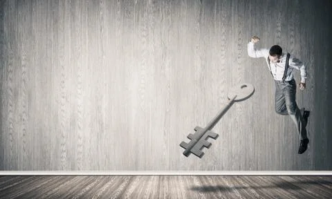 Breaking through access concept with man in room crashing concrete key Stock Photos