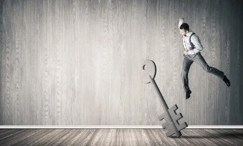 Breaking through access concept with man in room crashing concrete key Stock Photos
