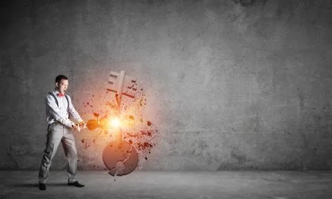 Breaking through access concept with man in room crashing concrete key 스톡 사진