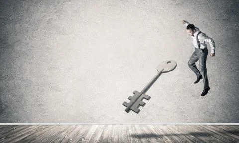 Breaking through access concept with man in room crashing concrete key Stock Photos